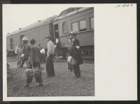 [recto] Transferees arriving at Tule Lake station on trip 15 from Topaz wait to be loaded into one of the Army trucks for conveyance to their new quarters. ;  Photographer: Mace, Charles E. ; , .