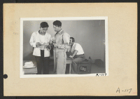 [recto] Poston, Ariz.--George Kita (left) and Norris James, WRA official, in an interview at this War Relocation Authority center during a CBS nationwide hookup. ;  Photographer: Clark, Fred ;  Poston, Arizona.