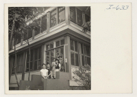 [recto] Kay Sunahara, Akira Taniguchi, and Lillian Funakubo, Nisei boarders, are pictured on the front steps of the pleasant boarding house ...