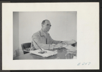 [recto] Ray D. Johnston, the Project Director at this center, seated at his desk in the Administrative Office. ;  Photographer: Parker, Tom ;  McGehee, Arkansas.