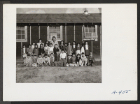 [recto] Low fifth grade pupils and their teacher, Mrs. Rhoda McGarva, outside the barracks school room. ;  Photographer: Stewart, Francis ;  Newell, California.
