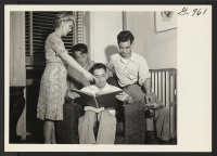 [recto] Mrs. Eldon Burke, director of the Brooklyn Hostel for Japanese Americans, shows an album of clippings to Robert Kazahaya, Kohay ...