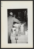 [recto] Mess operations in the segregation kitchen baggage car progressed while loading was under way. ;  Photographer: Lynn, Charles R. ;  Dermott, Arkansas.