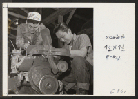 [recto] In the motor pool repair station. George Baba and Toki Umeda begin over hauling a truck loader. Motorized equipment at the center is maintained by qualified mechanics volunteered from center residents (former west coast persons of Japanese ancestry). ;