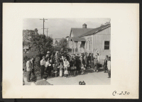 [recto] Farm families of Japanese ancestry awaiting the evacuation buses which will take them to the Tanforan Assembly Center along with 595 other evacuees from this district under Civilian Exclusion Order No. 34. ;  Photographer: Lange, Dorothea ;  Centervil