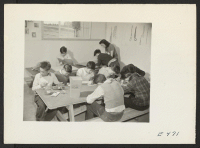 [recto] A junior high class in art. Aside from trinkets and the ordinary high school [illegible] the boys make many useful objects that contribute to the comfort of their barracks homes. ;  Photographer: Parker, Tom ;  Amache, Colorado.