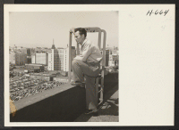[recto] Tech. Sgt. Minoru Masukane, believed first Nisei discharged from Army on points, looks over the city of Los Angeles from ...