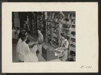 [recto] Typical scene in the Community Enterprise Stores at the Heart Mountain Relocation Center. Chief stocked item are tobacco, drug sundries, ...