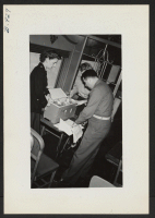 [recto] An army medical officer and two army nurses attached to the segregation train inspecting special baby formulas prepared for the trip. ;  Photographer: Lynn, Charles R. ;  Dermott, Arkansas.