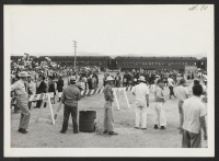 [recto] Looking from the induction house--arrivals lined up waiting to be inducted.--INCOMING ;  Photographer: Aoyama, Bud ;  Heart Mountain, Wyoming.