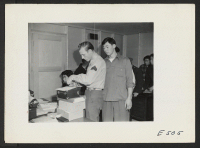 [recto] An Army sergeant finger prints Howard Uno, a loyal Nisei, who has been recruited in the United States Army. Howard will leave his wife and baby at the center, probably for the duration at the Amache Relocation Center. ;  Photographer: Parker, Tom ;  A