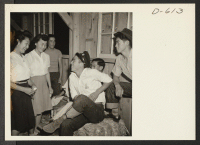 [recto] Two young girl evacuees of Japanese ancestry invite their boy friends to dance at a barn dance given by Block 12. ;  Photographer: Stewart, Francis ;  Poston, Arizona.