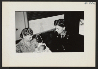 [recto] Army nurses holding an evacuee baby and seated in the first aid station of the September 25 segregation train from Jerome to Tule Lake. ;  Photographer: Lynn, Charles R. ;  Dermott, Arkansas.