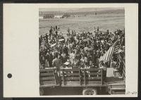 [recto] A young doctor of Japanese parentage addresses the gathered crowd at dedication ceremonies for the new hospital at the Topaz Relocation Center. ;  Photographer: Parker, Tom ;  Topaz, Utah.