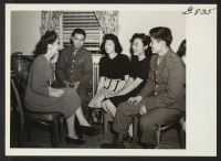 [recto] These Nisei soldiers and girls are being made at home by a hostess at the Nyack, N.Y., USO at a ...