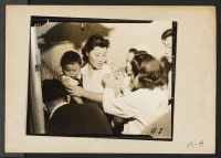 [recto] Evacuees of Japanese ancestry are being vaccinated by fellow evacuees upon arrival at the assembly centers. ;  Photographer: Albers, Clem ;  Arcadia, California.