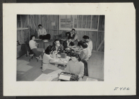 [recto] Evacuees on the newspaper staff at work in their office. ;  Photographer: Parker, Tom ;  Denson, Arkansas.