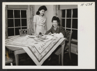 [recto] Miss Julie Sugimoto (left) and her sister, June (right), work in the home of the Burchette family in Peoria, Illinois. ...