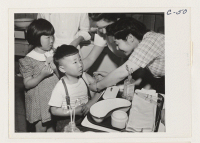 [recto] Evacuees of Japanese ancestry are vaccinated by fellow evacuees. ;  Photographer: Albers, Clem ;  Arcadia, California.