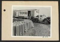 [recto] Poston, Ariz.--(Site #1)--Unloading roofing paper to be used in the construction of barracks at the Colorado River War Relocation Authority center for evacuees of Japanese ancestry. ;  Photographer: Clark, Fred ;  Poston, Arizona.