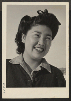 [recto] A young Nisei girl, Alice Hifumi, 17. Alice is a high school student and part time mess hall waitress. ;  Photographer: Parker, Tom ;  Heart Mountain, Wyoming.