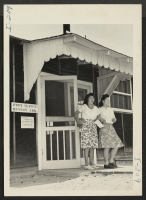 [recto] Closing of the Jerome Center, Denson, Arkansas. A view of the Denson Post Office in the Jerome Center. Two young ladies are seen coming out after leaving a notice of Change of Address as requested in the bulletin board. ;  Photographer: Iwasaki, Hikaru