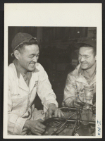 [recto] Frank Kishi, Issei formerly of Los Angeles and Colorado River Center, with a fellow worker at Shelly Motors, Kansas City, ...