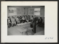 [recto] Senior Physics Class in Barracks 11-F at the temporary High School quarters. D. L. Cook. ;  Photographer: Parker, Tom ;  McGehee, Arkansas.