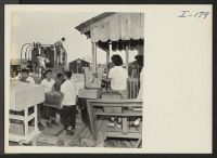 [recto] Closing of the Jerome Center, Denson, Arkansas. Scene in one of the block streets as transportation crews carry personal belongings from the one room residences and load them on trucks. ;  Photographer: Iwasaki, Hikaru ;  Denson, Arkansas.