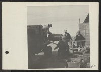 [recto] A crew delivering U.S. Army No.1 Space Heaters to a resident barracks at the Topaz Center. ;  Photographer: Parker, Tom ;  Topaz, Utah.