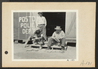 [recto] Poston, Ariz.--Members of the police department carving clubs at this War Relocation Authority center for evacuees of Japanese ancestry. (L to R) standing: Chief Kiyoshi Shigekawa; Toshio Ikeda and Hitoshi Nitta. ;  Photographer: Clark, Fred ;  Poston