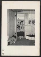 [recto] Arcadia, Calif.--Entering her new temporary apartment at the Santa Anita Assembly center to await transfer to a War Relocation Authority center where evacuees of Japanese ancestry will spend the duration. ;  Photographer: Albers, Clem ;  Arcadia, Cali