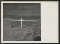 [recto] Tule Lake Relocation Center as seen from the summit of a nearby mountain. The cross was erected by the evacuee residents for an Easter Sunrise Service this year. ;  Photographer: Mace, Charles E. ;  Newell, California.