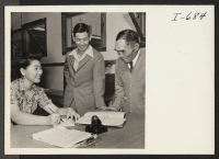 [recto] Torao Suyehiro (left) and Shoichi Akutagawa, from the Heart Mountain Center, being interviewed in the personnel relations department of Seabrook ...