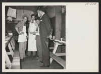 [recto] Roscoe Bell, WRA representative aboard trip 15, Topaz to Tule Lake, is shown in the dining car in a huddle with two of the cooks and the train monitor. ;  Photographer: Mace, Charles E. ; , .