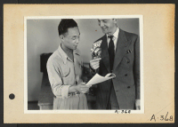 [recto] Poston, Ariz.--Kay Nishimura with Announcer Chet Huntley of CBS in a nationwide broadcast at this War Relocation Authority center for evacuees of Japanese ancestry. ;  Photographer: Clark, Fred ;  Poston, Arizona.