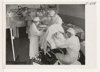 [recto] In one of the two hospital operating rooms at the center, Dr. Gerald A. Duffy, resident physician, assisted by chief resident Japanese physician, Dr. S. Yamada, performs an emergency appendectomy. ;  Photographer: Parker, Tom ;  Amache, Colorado.