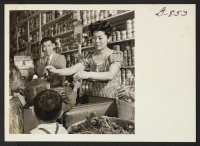 [recto] Mrs. Asaka hands out soda pop to neighborhood children in the grocery store which she and her husband own. Harry ...