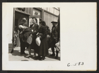 [recto] Oakland, Calif. (1117 Oak Street)--Evacuee family of Japanese ancestry leaving WCCA Control Station to board a bus which will take them to Tanforan Assembly Center. ;  Photographer: Lange, Dorothea ;  Oakland, California.