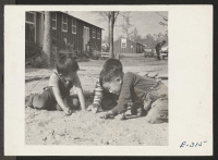 [recto] Three small boys compete in a stiff marble game on a Sunday afternoon in Block [cut off]. ;  Photographer: Parker, Tom ;  McGehee, Arkansas.