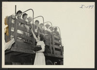 [recto] Closing of the Jerome Center, Denson, Arkansas. A teacher in the Jerome school bids goodbye to some of her little pupils as they wait in the trucks to be put on the trains to other centers. ;  Photographer: Iwasaki, Hikaru ;  Denson, Arkansas.