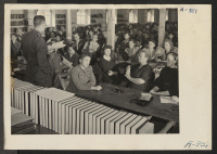 [recto] Lt. Eugene Bogard explaining the methods of registration to appointed personnel at this relocation center. ;  Photographer: Stewart, Francis ;  Manzanar, California.