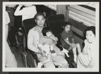 [recto] Topaz family settled down in Tule Lake bound train. ;  Topaz, Utah.