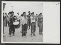 [recto] The fact that one arm was in a sling did not prevent the young lad from taking his place in the Topaz Boys Drum Corps as they played for departing residents bound for Tule Lake. ;  Photographer: Mace, Charles E. ;  Topaz, Utah.