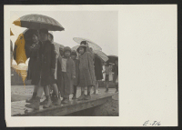 [recto] School children leaving the grade school. At the Jerome Relocation Center, where 8,000 persons of Japanese ancestry who formerly resided in California now reside. The rainy season in the lowlands of Arkansas have created mud and drainage problems for the