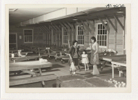 [recto] The dining room of the temporary housing project at Camp Funston, near Ocean Park in San Francisco. Each family does its own cooking and serving, and volunteers maintain the kitchen and dining room. Food is available through a community owned store. ;