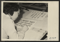[recto] In the poster shop at the Heart Mountain Relocation Center, a young artist completes the first draft of a general ...