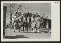 [recto] Manzanar, Calif.--Enjoying an afternoon stroll at this War Relocation Authority center for evacuees of Japanese ancestry. ;  Photographer: Lange, Dorothea ;  Manzanar, California.