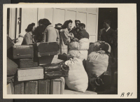 [recto] With baggage stacked, young residents of Japanese ancestry await bus at Wartime Civil Control Administration station, 2020 Van Ness Avenue, ...