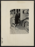 [recto] Eden, Idaho--This evacuee has just arrived by train with 600 others from the Puyallup assembly center and is boarding one of the waiting buses for the Minidoka War Relocation Authority center. ;  Photographer: Stewart, Francis ;  Hunt, Idaho.